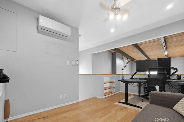 home office with track lighting, baseboards, ceiling fan, an AC wall unit, and wood finished floors
