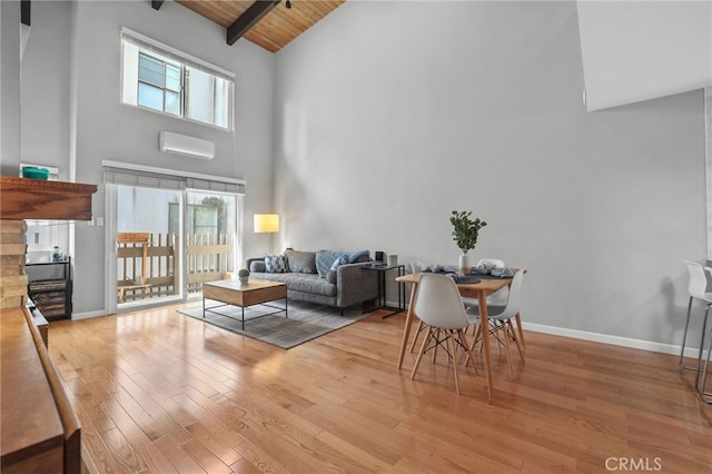 living room with beam ceiling, light wood-style flooring, wooden ceiling, and a healthy amount of sunlight