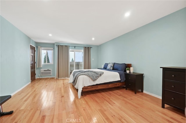 bedroom featuring recessed lighting, baseboards, light wood finished floors, and a wall mounted AC