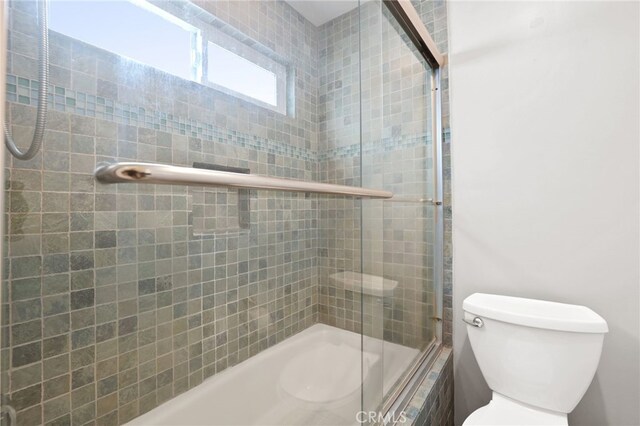 full bathroom featuring toilet and a tile shower