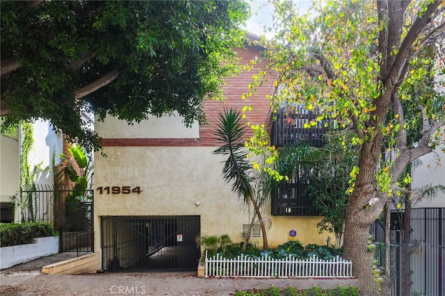 11954 Goshen Ave Unit 205, Los Angeles, CA 90049 - view of side of home featuring stucco siding, fence, and a gate