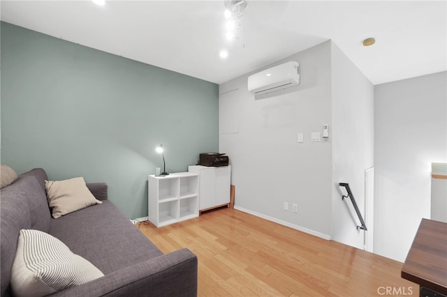 sitting room with light wood-type flooring, an upstairs landing, baseboards, and a wall unit AC