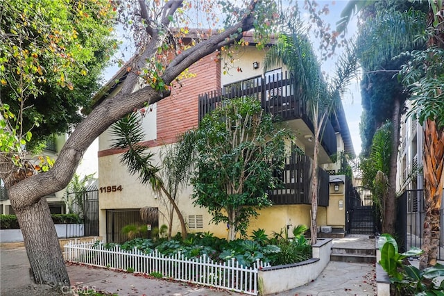 11954 Goshen Ave Unit 205, Los Angeles, CA 90049 - view of front of house featuring stucco siding, fence, and a gate