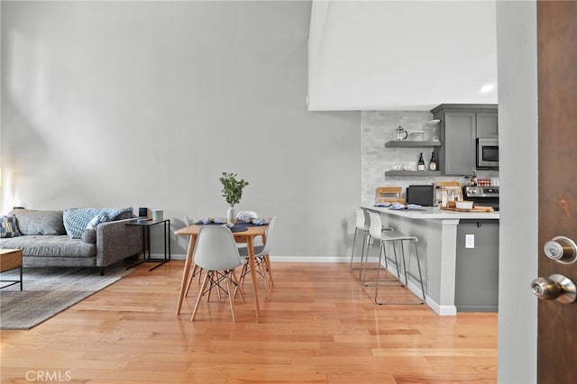 dining space with baseboards and light wood finished floors