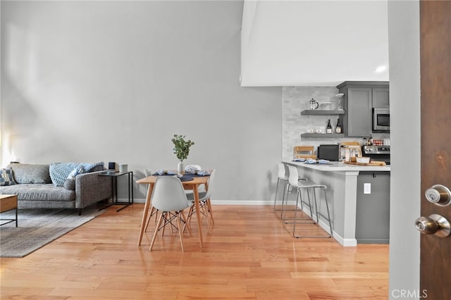dining space featuring light wood finished floors and baseboards