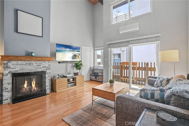 11954 Goshen Ave Unit 205, Los Angeles, CA 90049 - living room with healthy amount of natural light, a towering ceiling, a wall unit AC, wood finished floors, and a fireplace