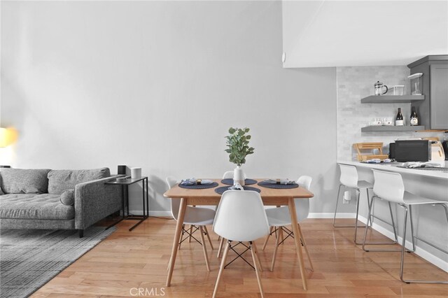 dining space with baseboards and light wood finished floors