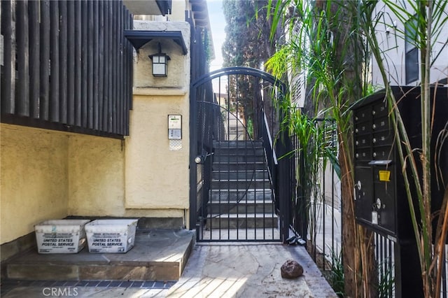 entrance to property featuring a gate and stucco siding