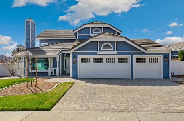 view of front of house with a garage, decorative driveway, and a tiled roof