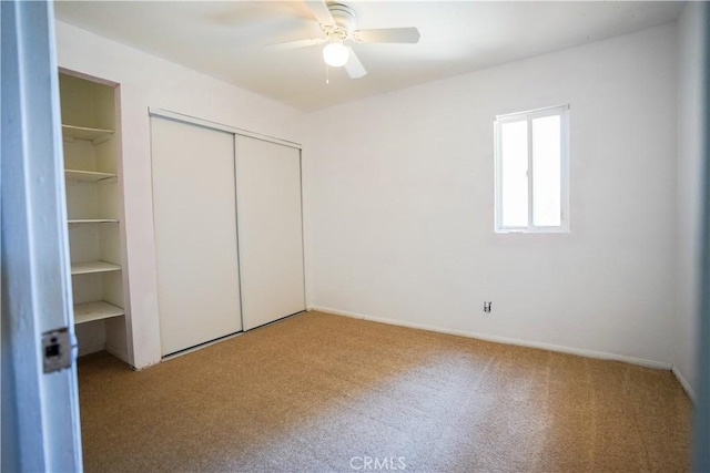 unfurnished bedroom with carpet, a ceiling fan, and a closet