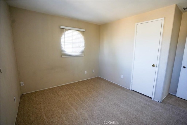 unfurnished bedroom with light colored carpet and visible vents