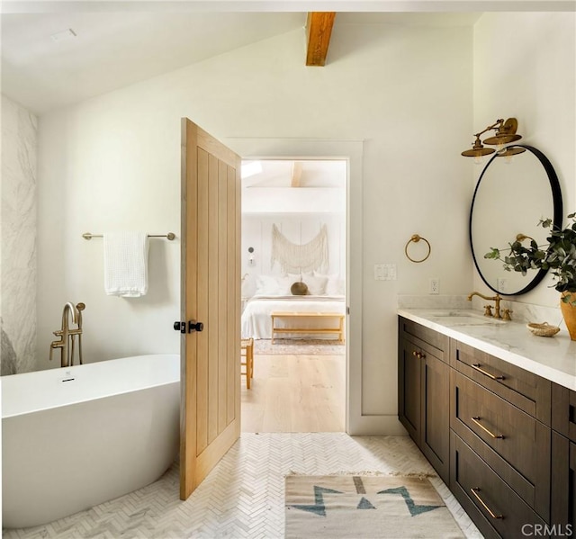 ensuite bathroom with lofted ceiling with beams, vanity, a soaking tub, tile patterned floors, and ensuite bath