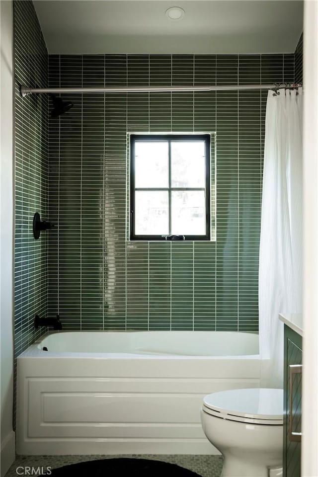 bathroom featuring shower / bath combo with shower curtain, toilet, and tile walls