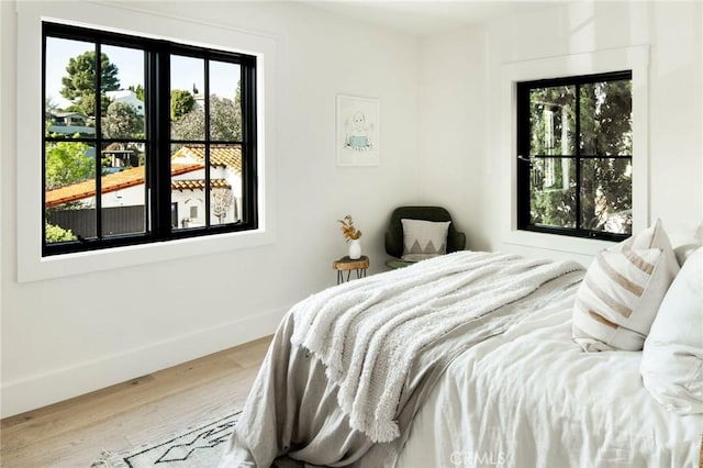 bedroom featuring wood finished floors and baseboards