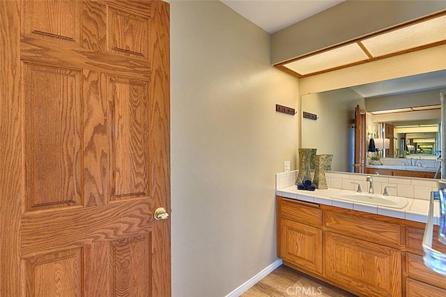 bathroom with vanity, baseboards, and wood finished floors