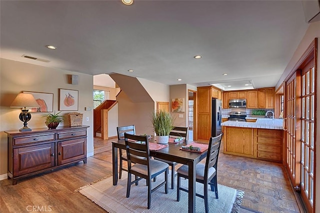 dining room with recessed lighting, visible vents, baseboards, and wood finished floors