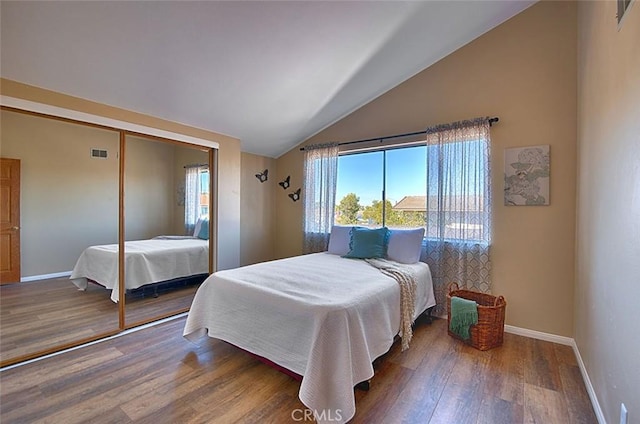 bedroom with visible vents, baseboards, wood finished floors, and vaulted ceiling