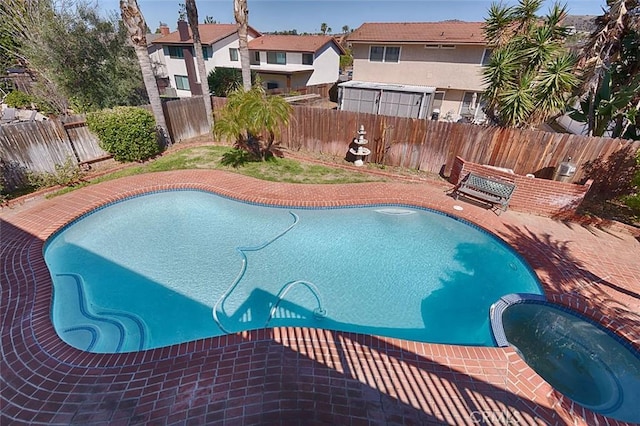 view of pool featuring a residential view, a pool with connected hot tub, a fenced backyard, and a patio area