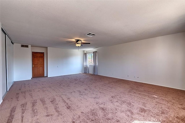 unfurnished room featuring visible vents, a textured ceiling, ceiling fan, and carpet floors