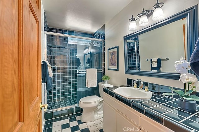 full bathroom featuring tile patterned floors, toilet, a stall shower, and vanity