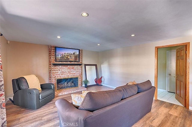 living room with recessed lighting, a fireplace, baseboards, and wood finished floors