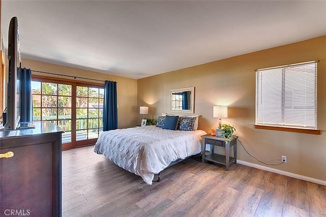 bedroom with access to outside, wood finished floors, and baseboards