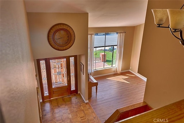 entryway with baseboards and parquet flooring