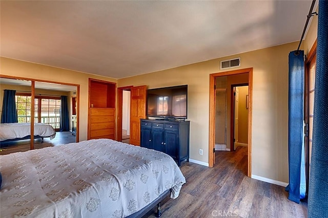 bedroom with dark wood finished floors, visible vents, and baseboards