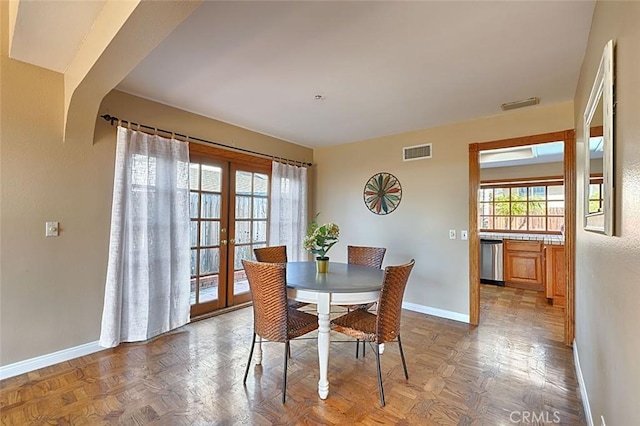 dining room with arched walkways, french doors, visible vents, and baseboards