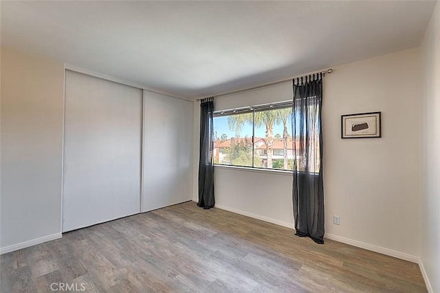 empty room featuring baseboards and wood finished floors