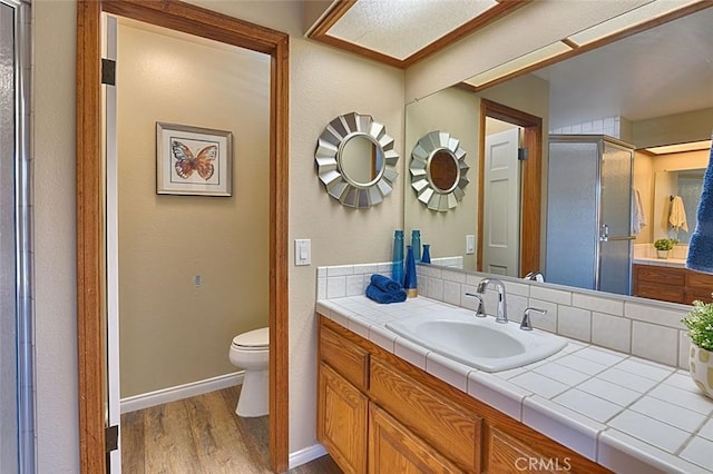 full bath with vanity, toilet, wood finished floors, and a shower stall