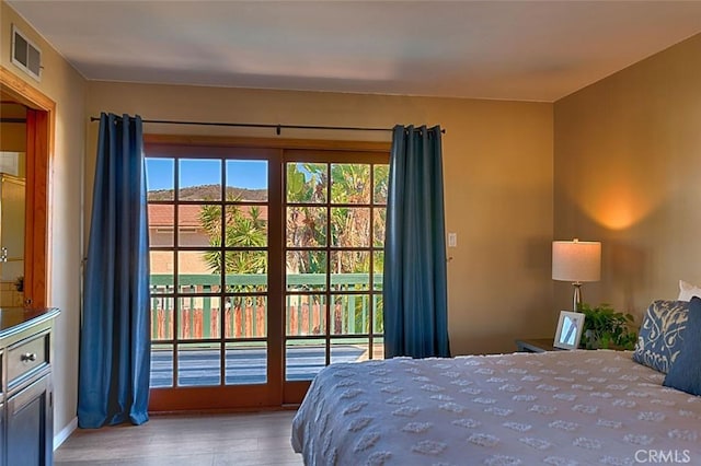 bedroom featuring visible vents, wood finished floors, and access to outside