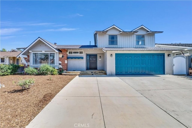 view of front of home with driveway, board and batten siding, an attached garage, and a gate