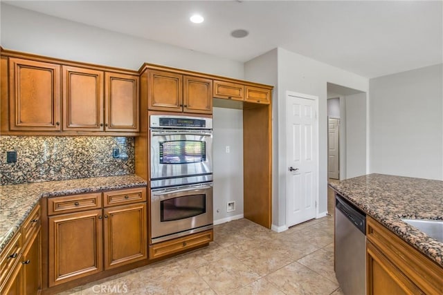 kitchen with stainless steel appliances, recessed lighting, tasteful backsplash, stone countertops, and brown cabinetry