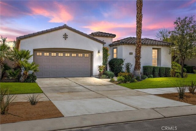 60310 Desert Rose Dr, La Quinta, CA 92253 - mediterranean / spanish-style house featuring a garage, driveway, a front yard, stucco siding, and a tiled roof