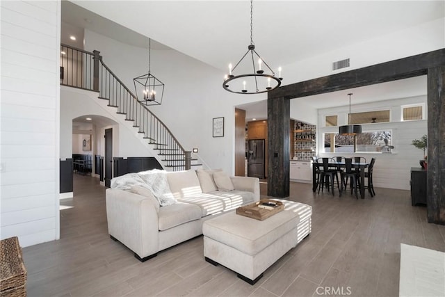 14201 Ross Ct, Rancho Cucamonga, CA 91739 - living area with a chandelier, wood finished floors, arched walkways, stairway, and a towering ceiling
