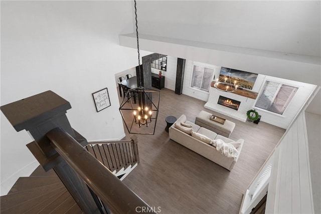 14201 Ross Ct, Rancho Cucamonga, CA 91739 - living room with a lit fireplace, a chandelier, and wood finished floors