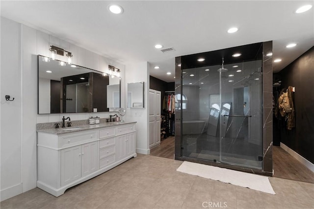 14201 Ross Ct, Rancho Cucamonga, CA 91739 - full bathroom featuring a shower stall, double vanity, recessed lighting, a spacious closet, and wood finished floors