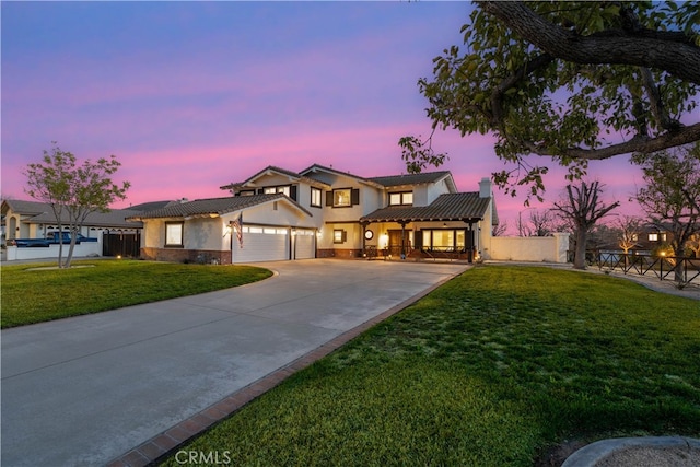 view of front of property featuring a chimney, stucco siding, concrete driveway, a garage, and a front lawn