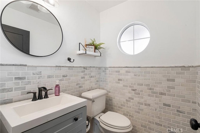 14201 Ross Ct, Rancho Cucamonga, CA 91739 - bathroom featuring vanity, tile walls, and a wainscoted wall