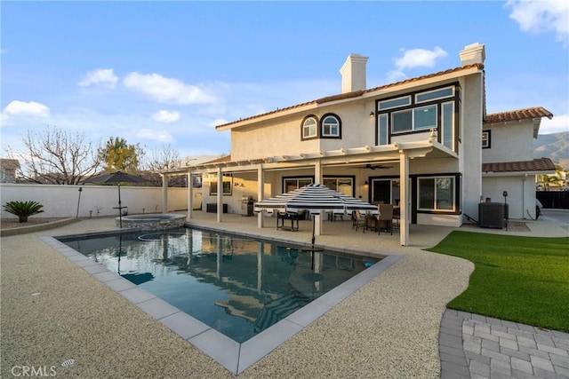 14201 Ross Ct, Rancho Cucamonga, CA 91739 - rear view of property with a chimney, a fenced backyard, a ceiling fan, stucco siding, and a pool with connected hot tub