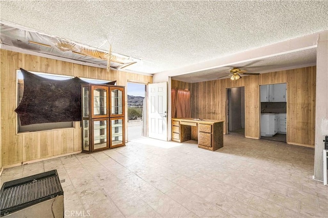 interior space with built in study area, wood walls, a textured ceiling, and light floors