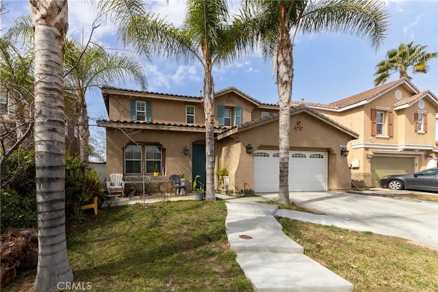 mediterranean / spanish-style house with a front yard, concrete driveway, an attached garage, and stucco siding