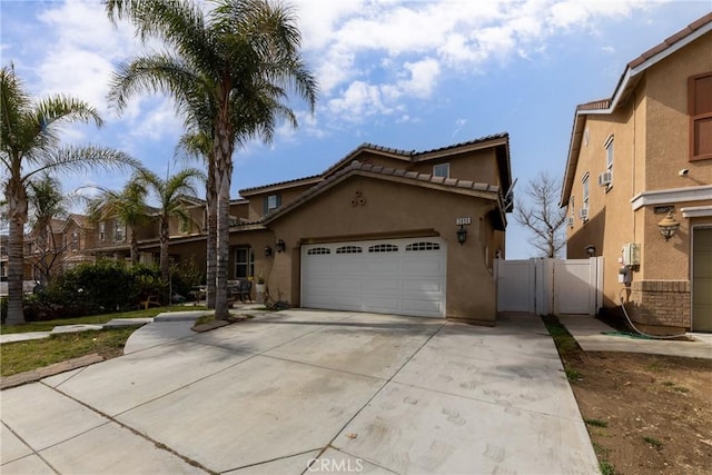 view of front of property featuring a garage, a gate, concrete driveway, and stucco siding