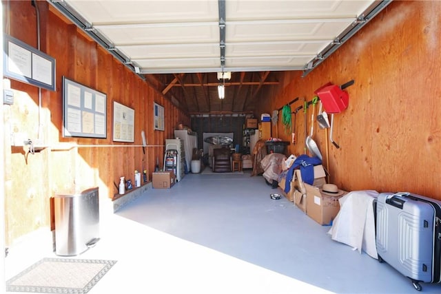 garage with a garage door opener and wood walls