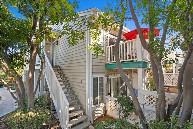 rear view of house featuring a balcony and stairway