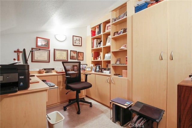 office area with lofted ceiling, a textured ceiling, and light colored carpet