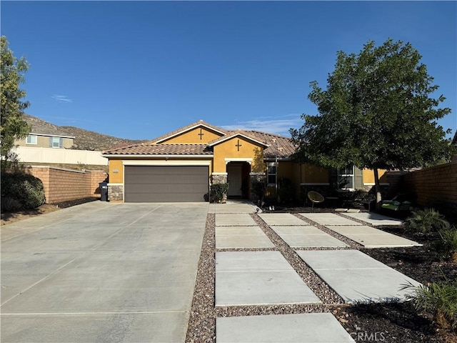 view of front of home featuring driveway, a tile roof, a garage, and stucco siding