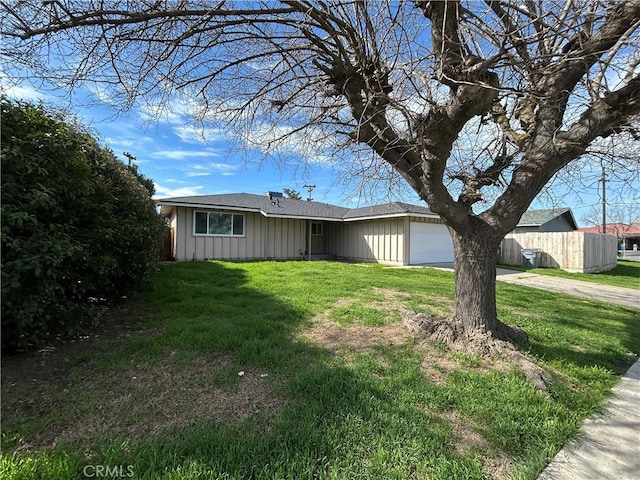 view of front of home with a garage, fence, a front lawn, and board and batten siding