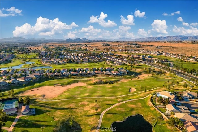 drone / aerial view with a residential view, view of golf course, and a water and mountain view